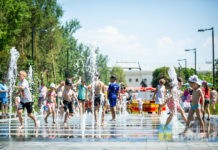 дети спасаются от жары в фонтане